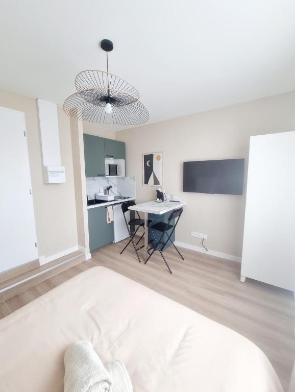 Cette chambre comprend un lit, une table et une cuisine. dans l'établissement L'Aiglon de Foch 3 #ACCES FAC#, à Grenoble