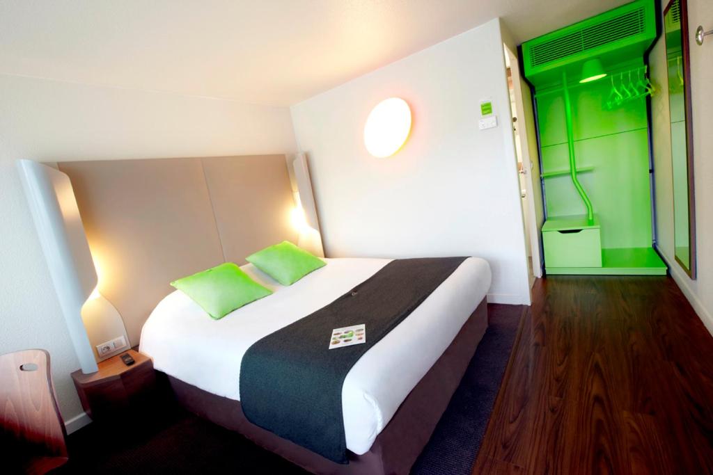 - une chambre avec un grand lit aux murs verts dans l'établissement Campanile Clermont-Ferrand ~ Riom, à Riom
