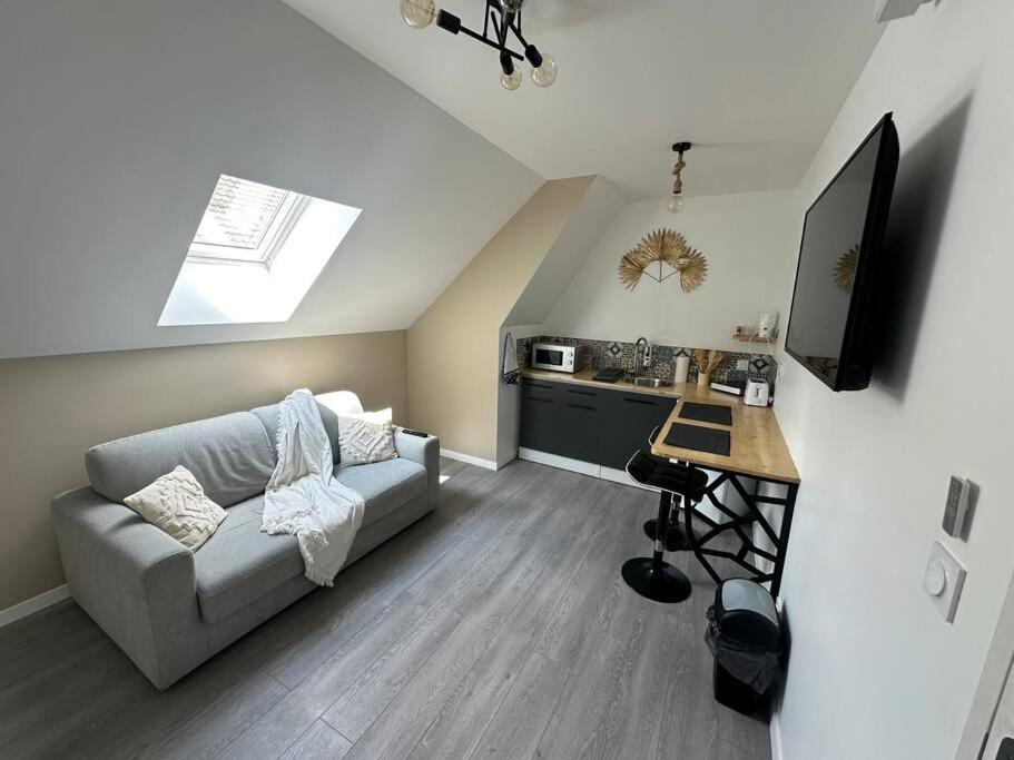 un salon avec un canapé et une table et une cuisine dans l'établissement Oslo 2 personnes, à Amiens