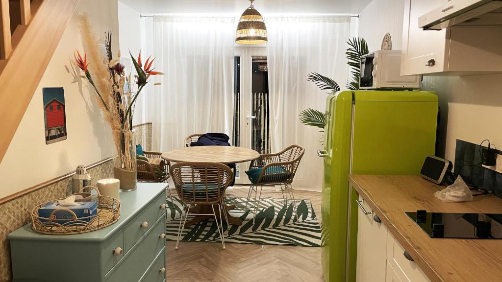 uma cozinha com uma mesa e um frigorífico verde em Voyage à Cocoa Beach em Bouguenais