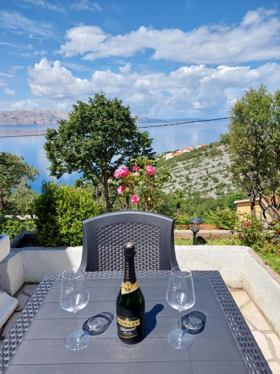a bottle of wine sitting on a table with wine glasses at Dalibor in Senj