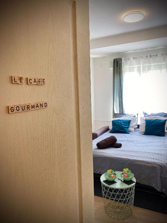 Cette chambre comprend un lit et une table avec des bols. dans l'établissement Studio Le café gourmand - Proche Gare - Coin tranquille, à Mulhouse