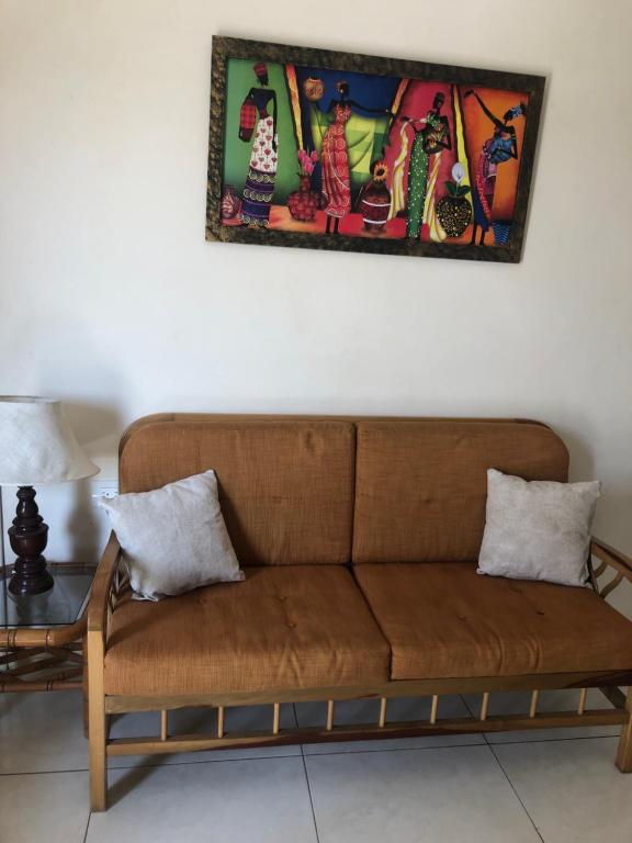 a brown couch sitting under a painting on a wall at Hospedaje Maluli suit 4 in Santa Elena