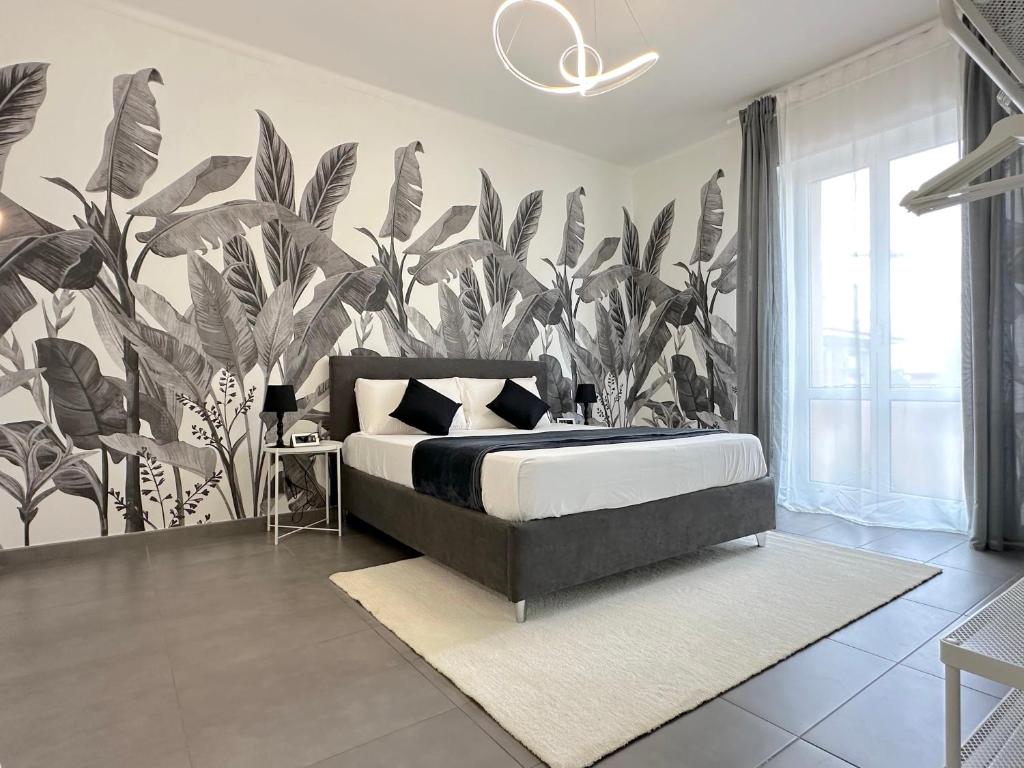 ein Schlafzimmer mit einem Bett mit einer großen Pflanzetapete in der Unterkunft Villa Laura Relais in Bologna