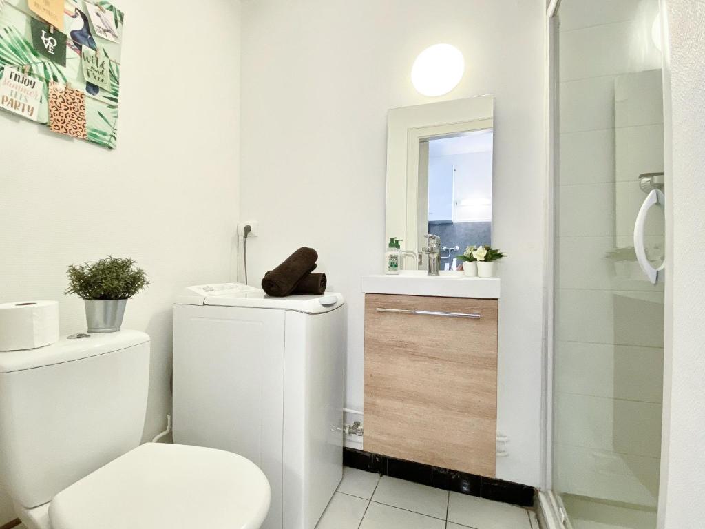 La salle de bains blanche est pourvue de toilettes et d'un lavabo. dans l'établissement Studio Le café gourmand - Proche Gare - Coin tranquille, à Mulhouse