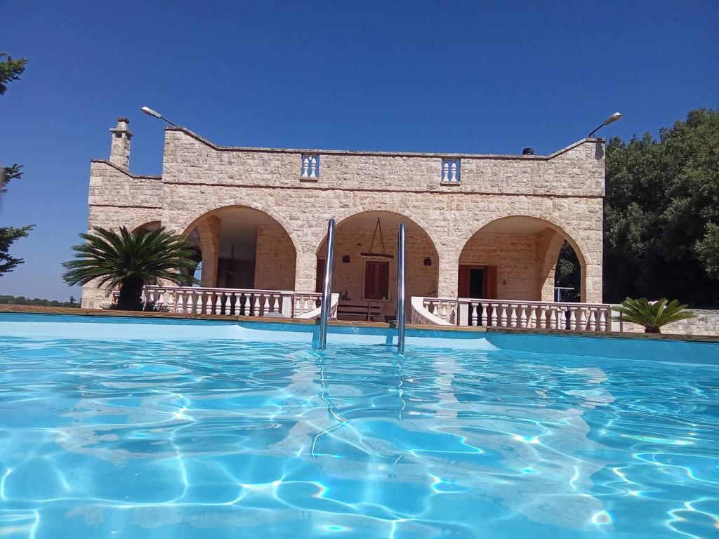 a swimming pool in front of a building at VILLA LISI in Selva di Fasano