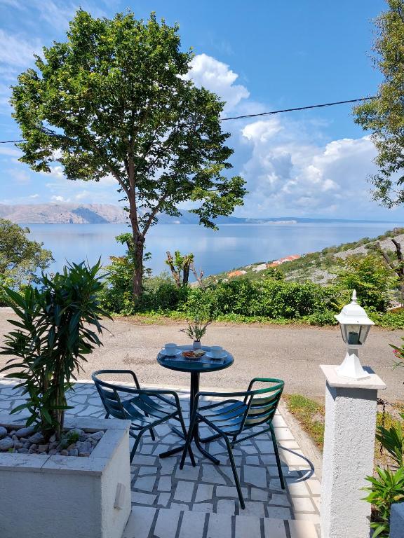 a table and chairs on a patio with a view of the water at Dalibor in Senj