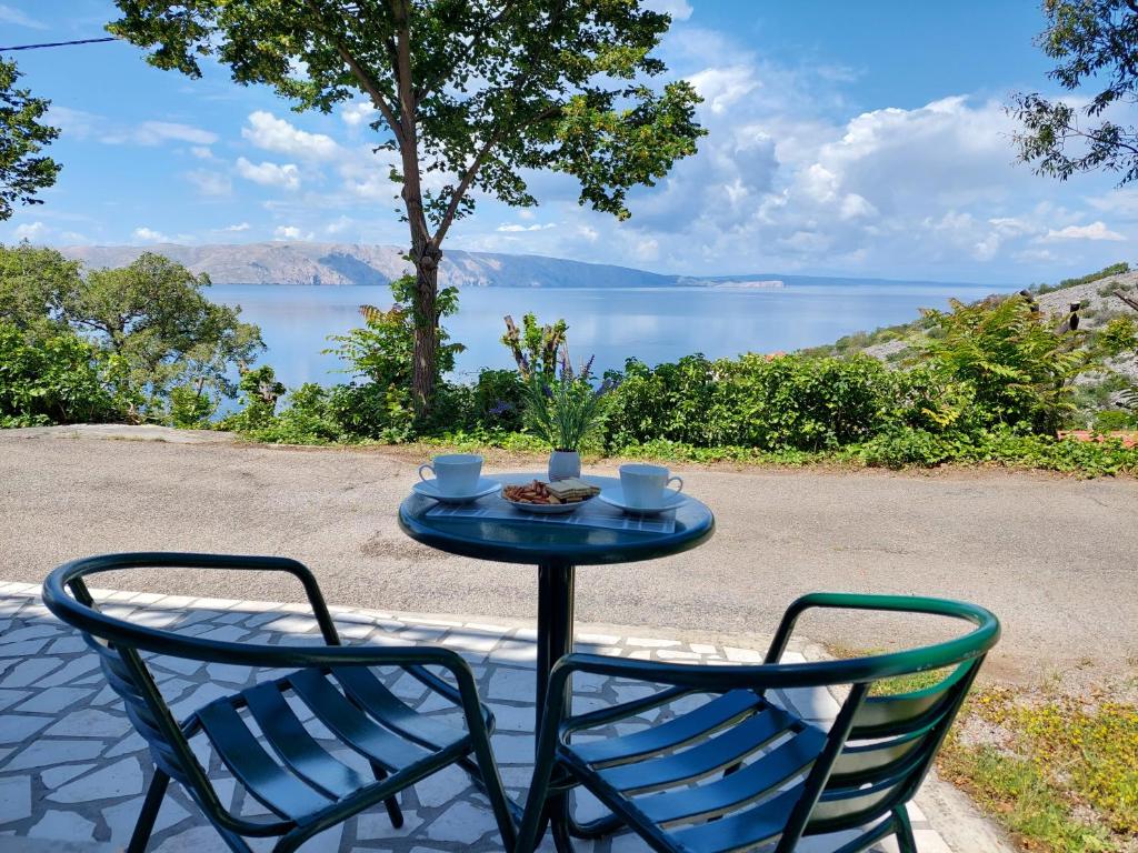 a table with two chairs and a table with a drink at Dalibor in Senj