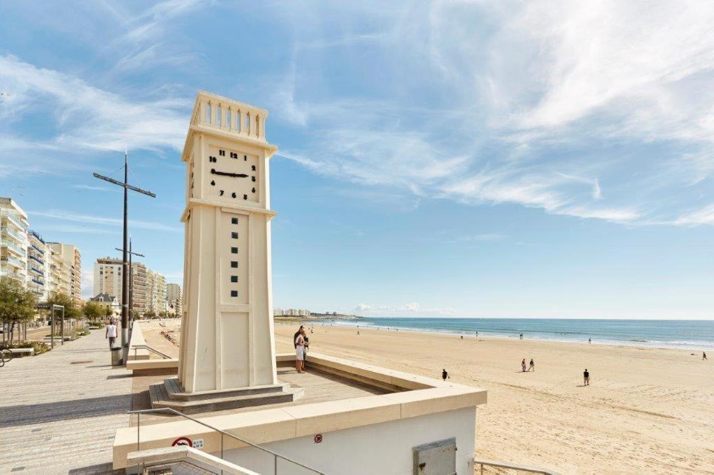 une tour de l'horloge sur la plage à côté de la plage dans l'établissement Appartement remblai 1 chambre Sortie direct plage, à Les Sables-dʼOlonne
