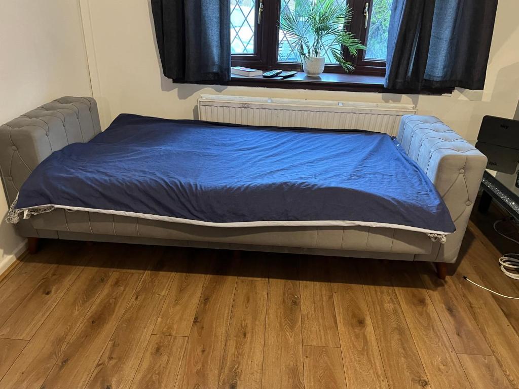 a bed with a blue blanket on it in a room at 5 bedroom modern detached house in Morriston