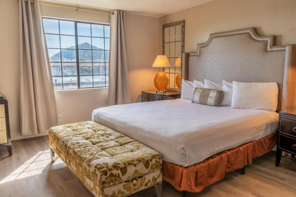 a bedroom with a large bed with a large window at Sands Inn & Suites in San Luis Obispo