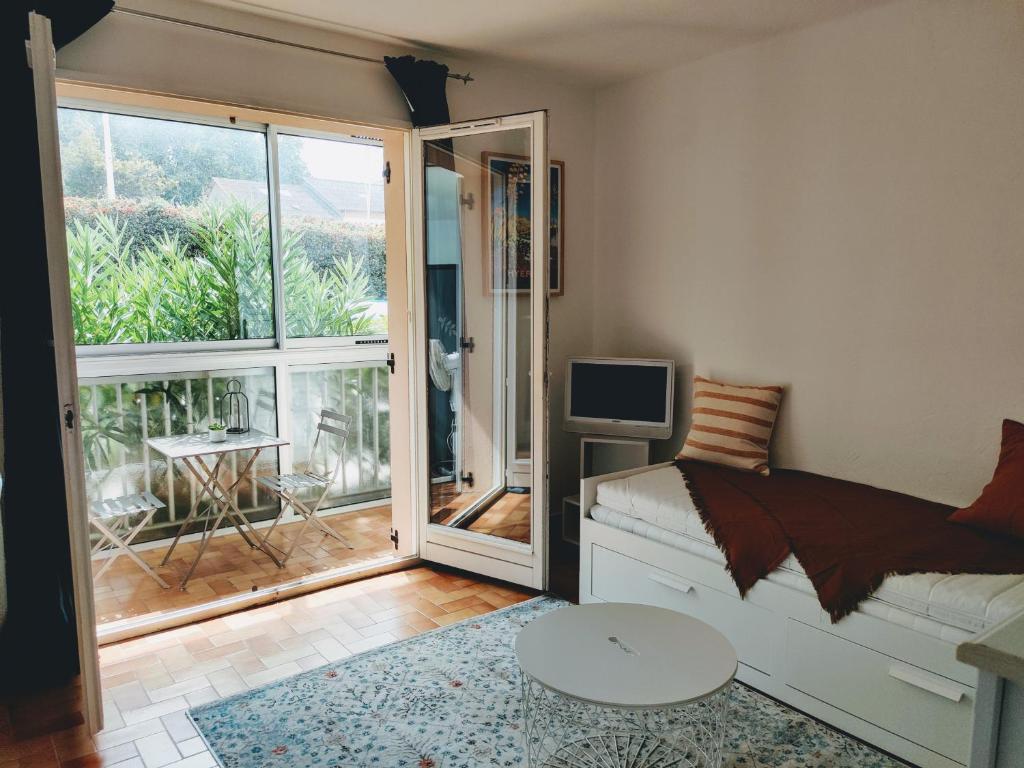 un salon avec un canapé et une porte coulissante en verre dans l'établissement Agréable studio proche plages et commerces, au Pradet