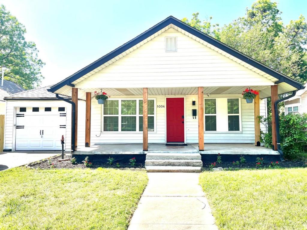 a house with a red door and a garage at Old Town Charm with 2 Bedrooms, 3 TVs in Lawton