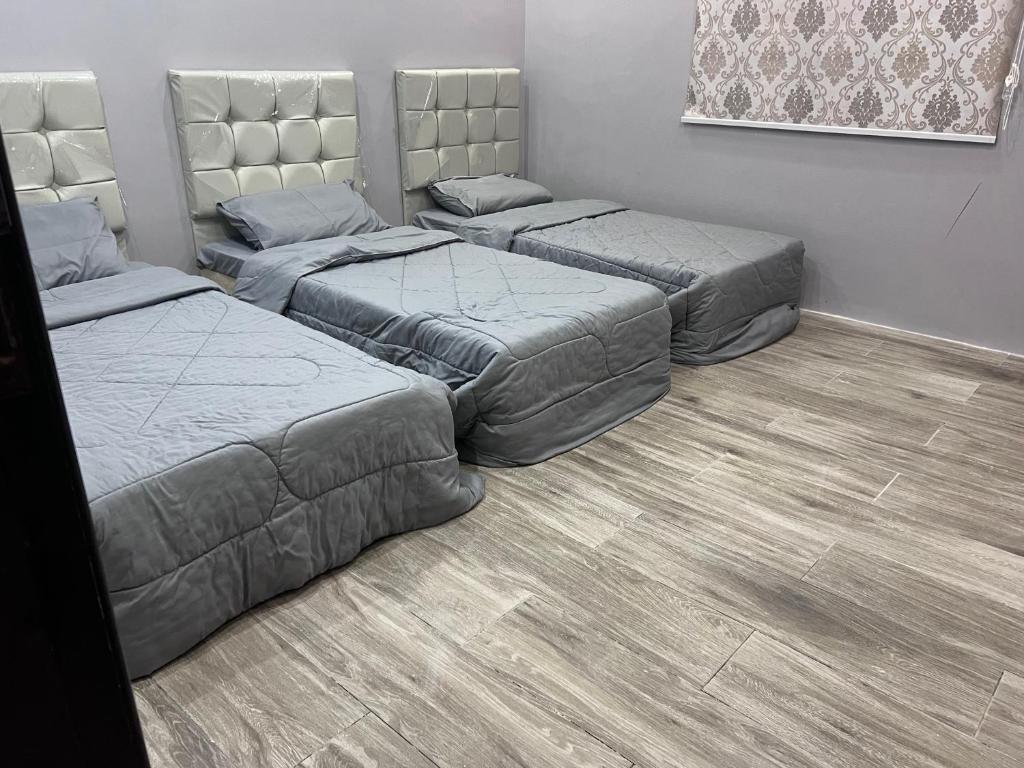 - 3 lits dans une chambre dotée de parquet dans l'établissement شقة نصف القمر, à La Mecque