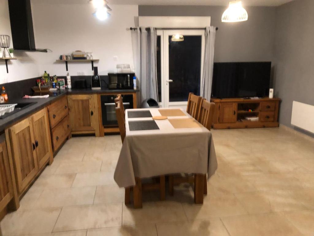 eine Küche mit einem Tisch und Stühlen sowie einem Tisch und einer Küche in der Unterkunft Charmant Logement avec piscine. in Valleraugue