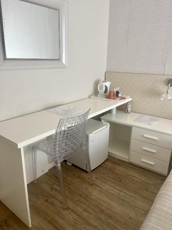 białe biurko z krzesłem i lustrem w obiekcie Hotel Villa Rosa w mieście Porto Azzurro