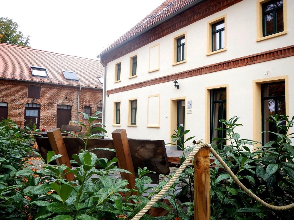 un jardin avec une corde en face d'un bâtiment dans l'établissement Gutshof Leipzig- Podelwitz Pension, à Rackwitz