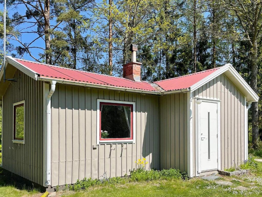a green and white shed with a red roof at Holiday home HOLMSJÖ III in Holmsjö