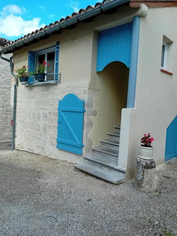 une maison avec une porte bleue et des escaliers dans l'établissement Chez Francine, à Lascabanes