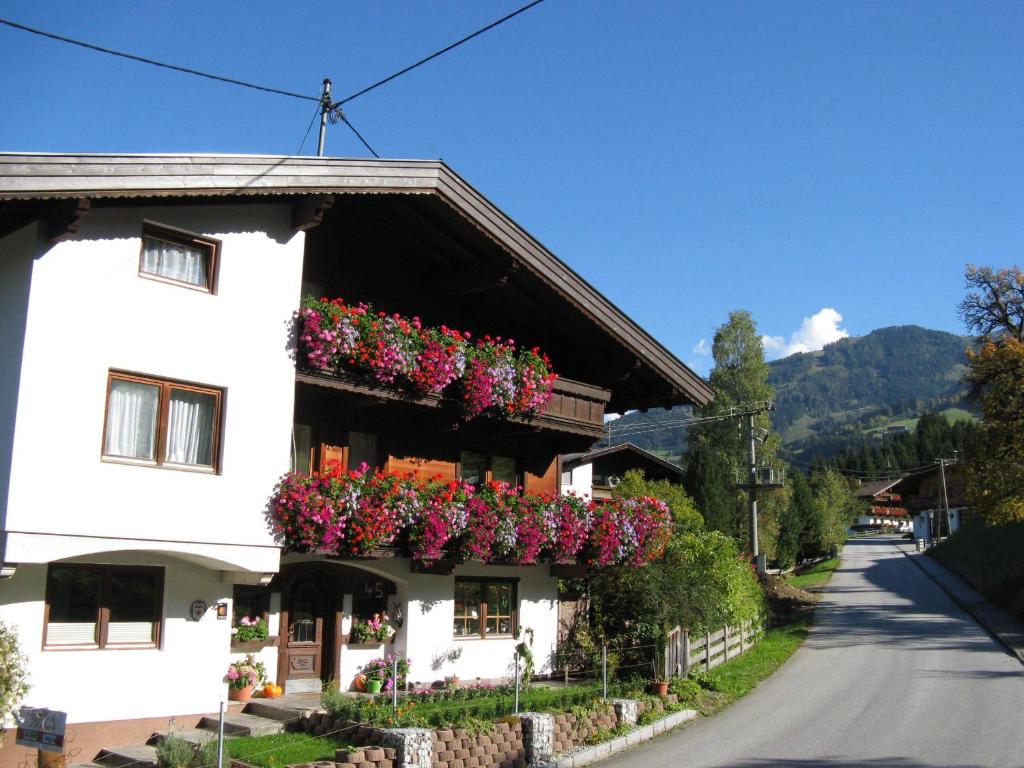 un bâtiment blanc avec des boîtes de fleurs sur lui dans l'établissement Alpbach Apartments, à Reith im Alpbachtal