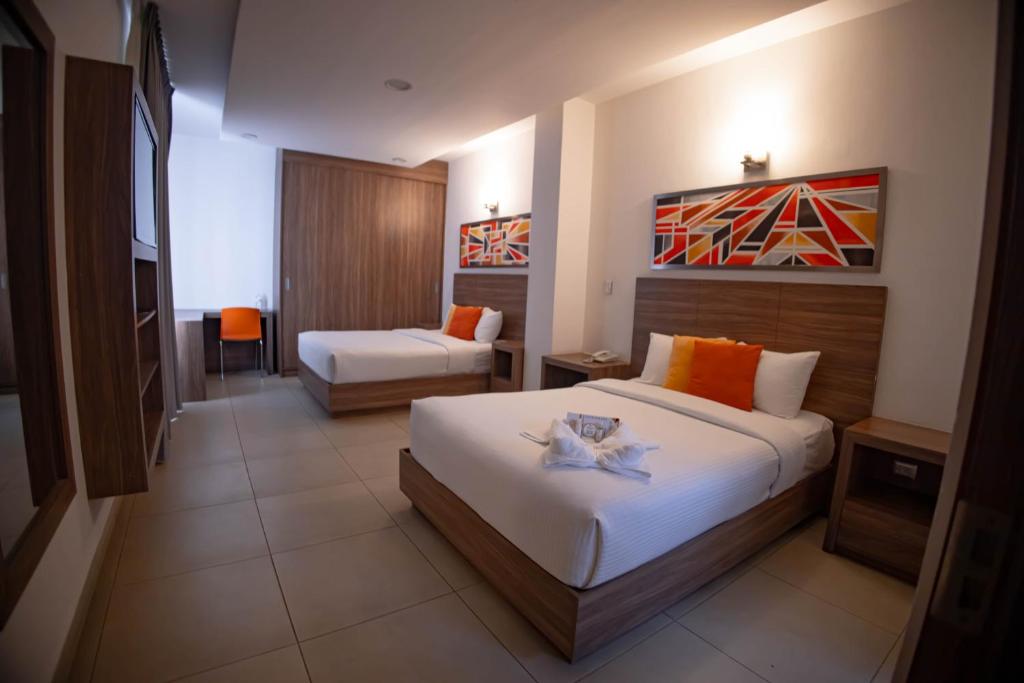 ein Hotelzimmer mit 2 Betten und einem Sofa in der Unterkunft Hotel Villa Express Durango in Durango
