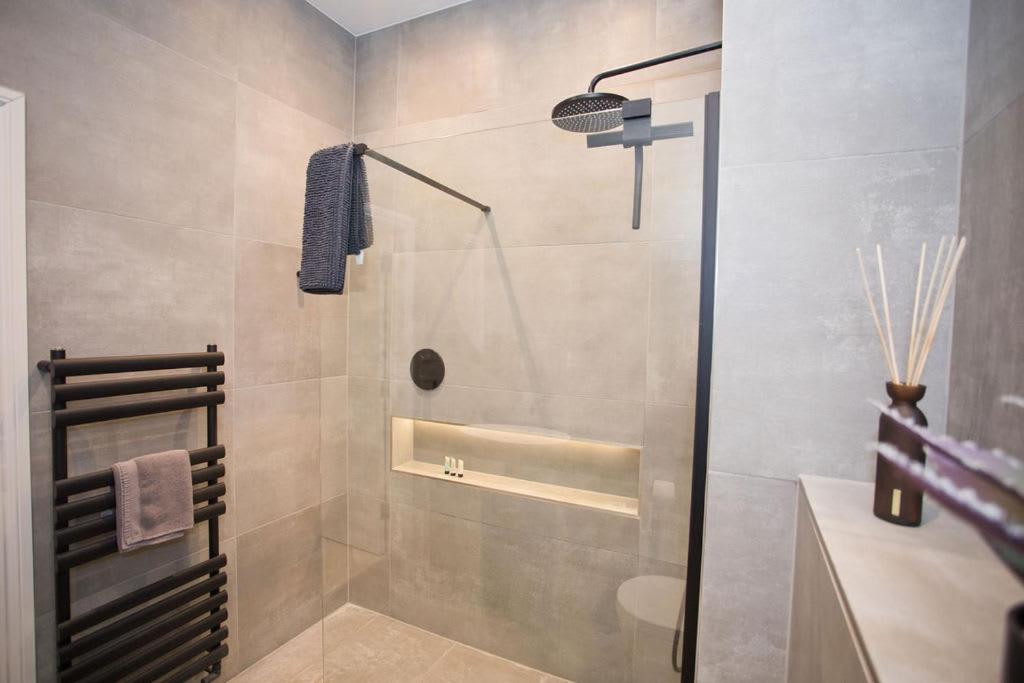a bathroom with a shower with a toilet and a sink at Ultra Stylish Apt set in an affluent location in Poole