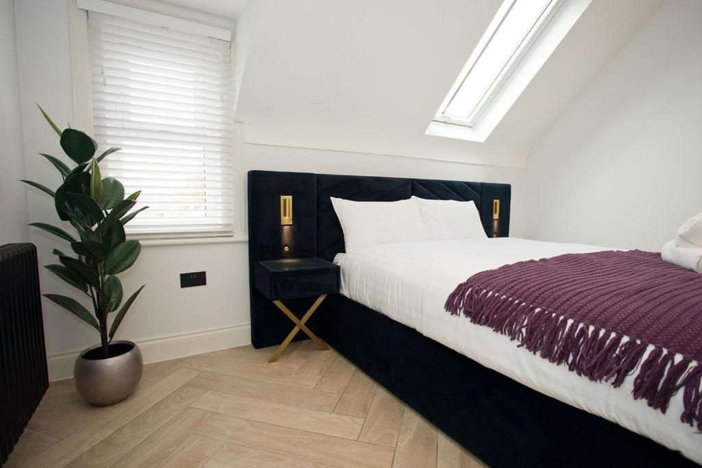 a bedroom with a bed and a potted plant at Ultra Stylish Apt set in an affluent location in Poole