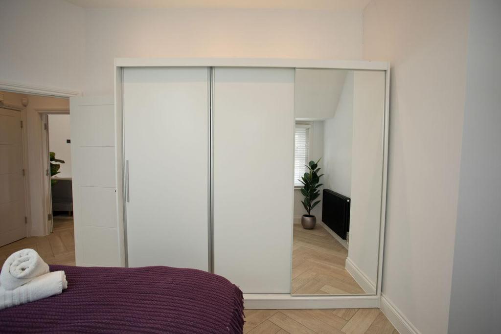 a bedroom with a large mirror in front of a bed at Ultra Stylish Apt set in an affluent location in Poole