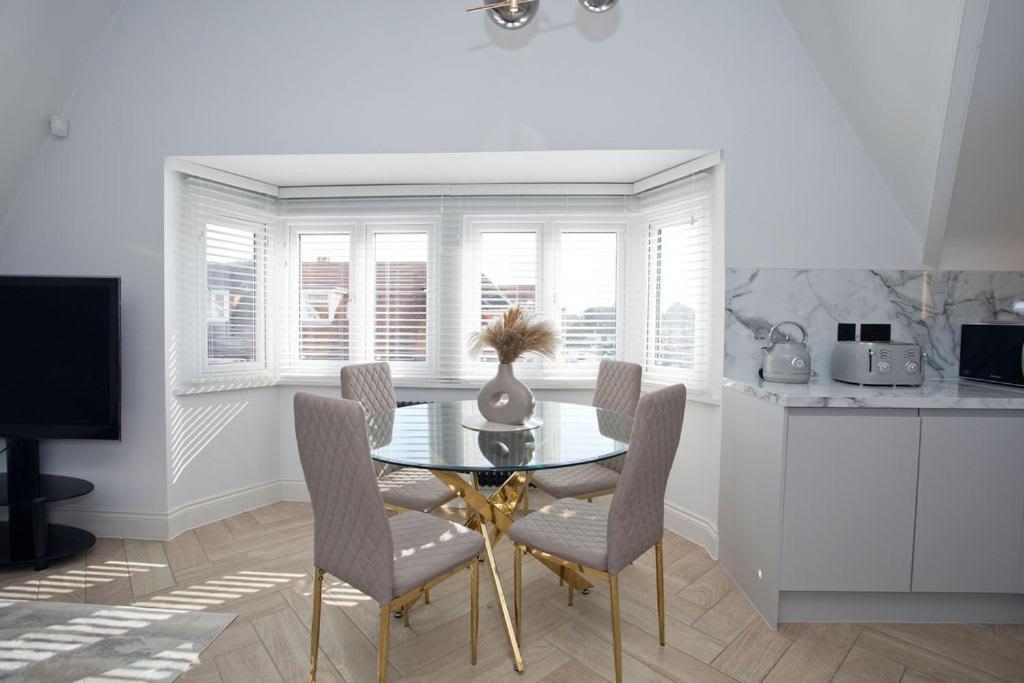 a dining room with a glass table and chairs at Ultra Stylish Apt set in an affluent location in Poole