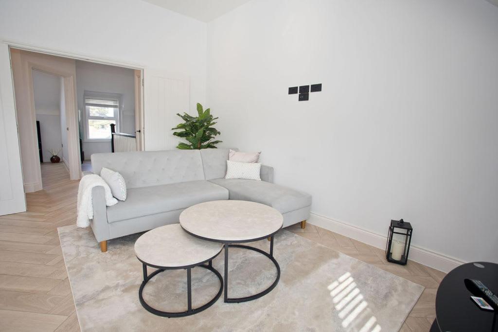 a living room with a couch and a table at Ultra Stylish Apt set in an affluent location in Poole