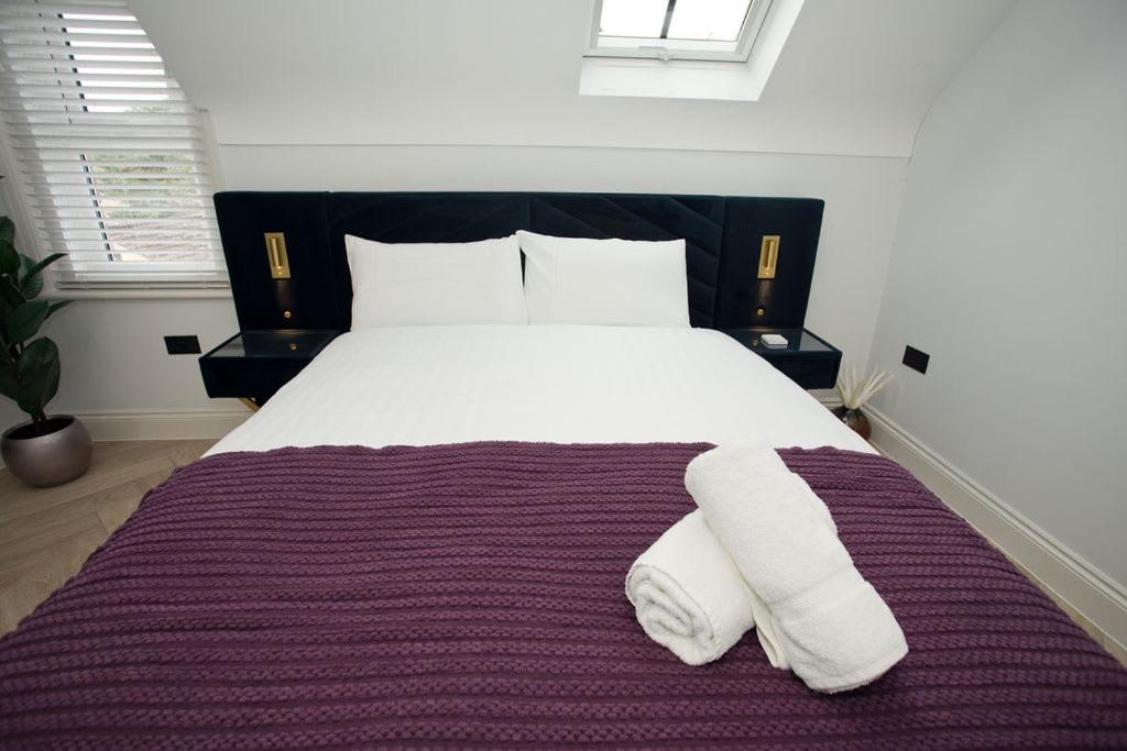 a bedroom with a large bed with two towels on it at Ultra Stylish Apt set in an affluent location in Poole