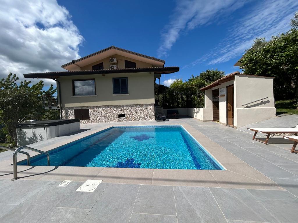a swimming pool in front of a house at Relais 5 Sensi WELLNESS & SPA in Bagnoli Irpino