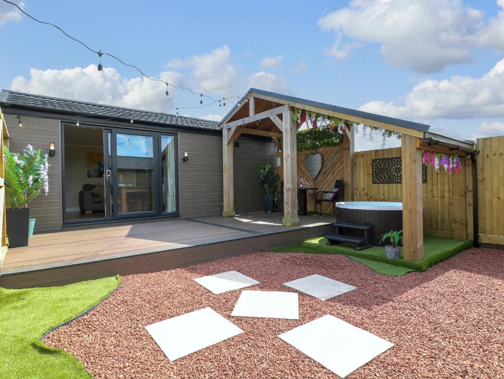 a backyard with a deck and a grill at Maple in Swadlincote