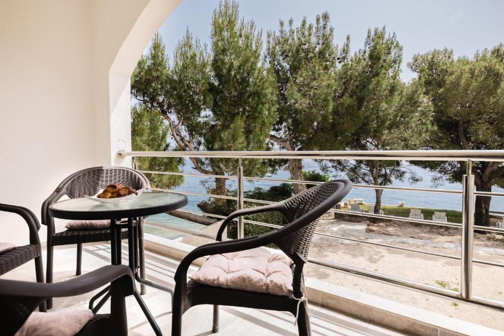 balkon ze stołem i krzesłami oraz widokiem na ocean w obiekcie Herceg Novi w mieście Herceg Novi