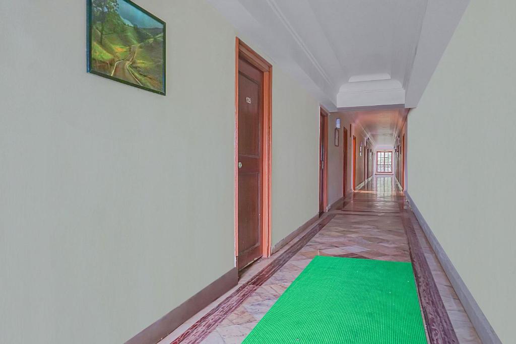 un pasillo con una alfombra verde en el suelo en Collection O Sukhsagar Resort, en Lonavala