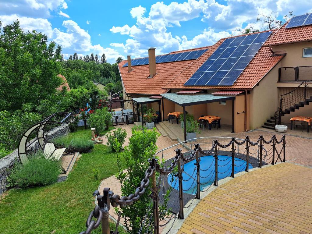 道喬尼托毛伊的住宿－Római Apartman，屋顶上设有太阳能板的游泳池的房子