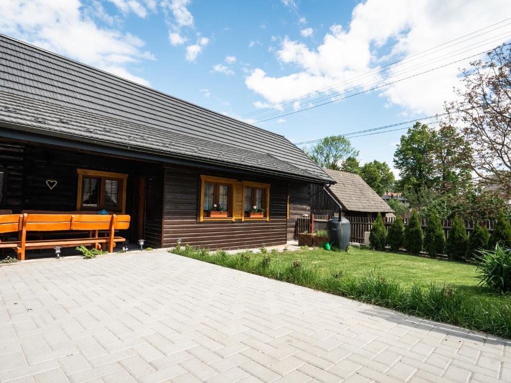 a wooden bench sitting outside of a house at Drevenička v Durčinej - Magdaléna in Ďurčiná