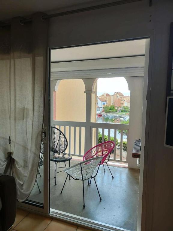 d'un balcon avec 2 chaises et une table sur la terrasse. dans l'établissement Résidence Pointe Vermeille - 2 Pièces pour 4 Personnes 321, au Barcarès