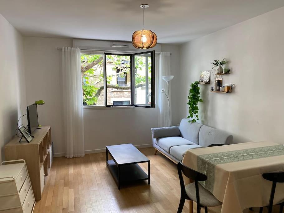 un salon avec un canapé et une table dans l'établissement Cosy F2 free parking 5 min metro near Seine, à Boulogne-Billancourt