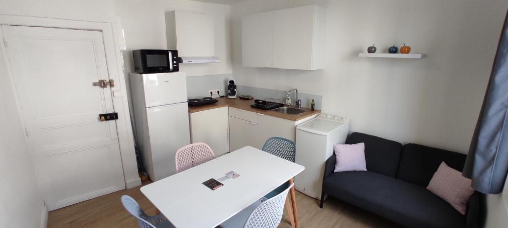 Ce petit appartement comprend une table et un canapé. dans l'établissement Appartement cosy plein centre, à Conches-en-Ouche
