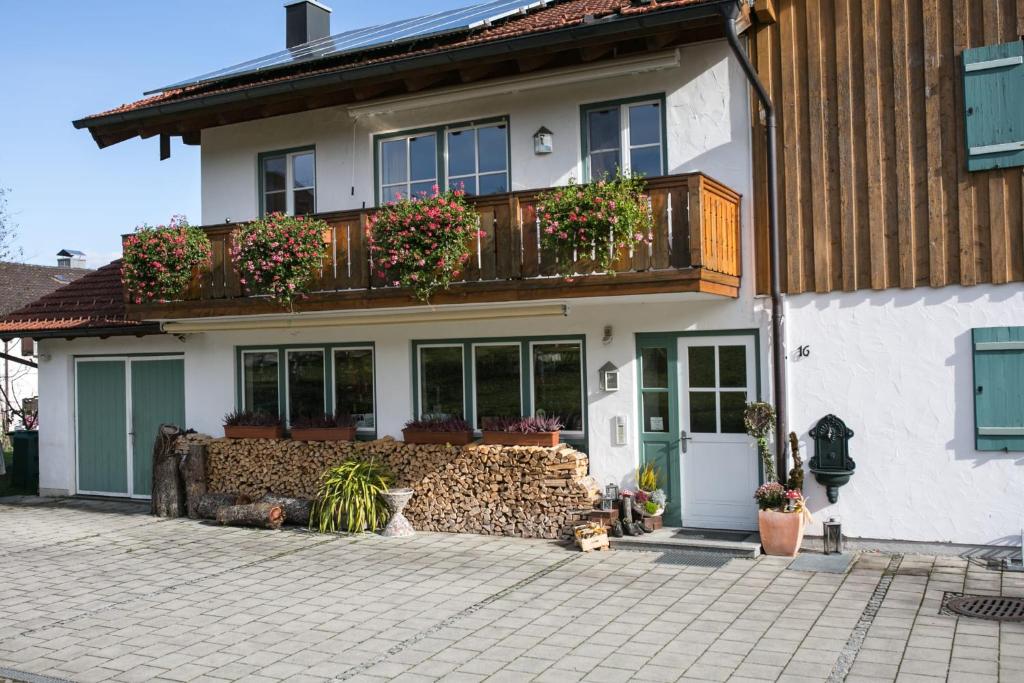 ein Haus mit einem Balkon mit Topfpflanzen darauf in der Unterkunft Ferienwohnung Bartl in Prien am Chiemsee