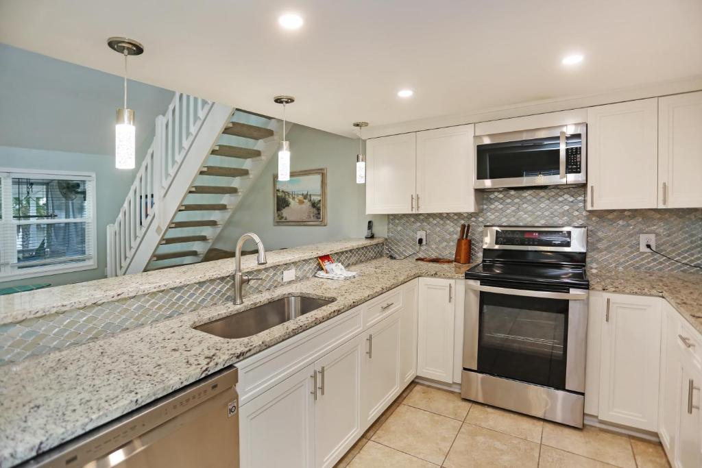 a kitchen with white cabinets and a sink at Sharkey's by Pristine Properties Vacation Rentals in Cape San Blas