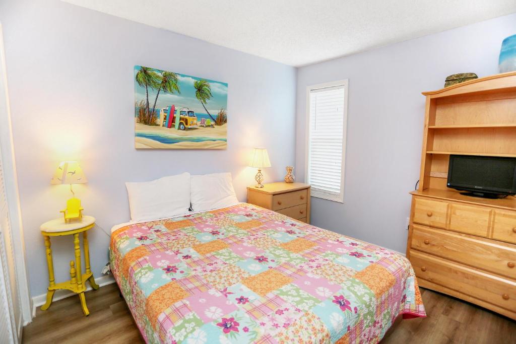 a bedroom with a bed and a dresser and a tv at Sharkey's by Pristine Properties Vacation Rentals in Cape San Blas