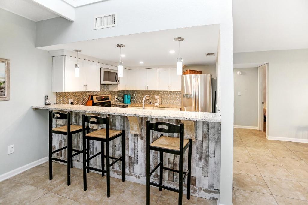 a kitchen with a counter and some stools at a bar at Sharkey's by Pristine Properties Vacation Rentals in Cape San Blas