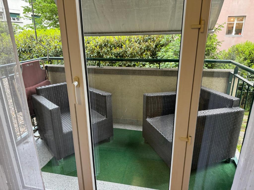 una puerta de cristal con vistas a un balcón en Apartahotel Confort en Lausana