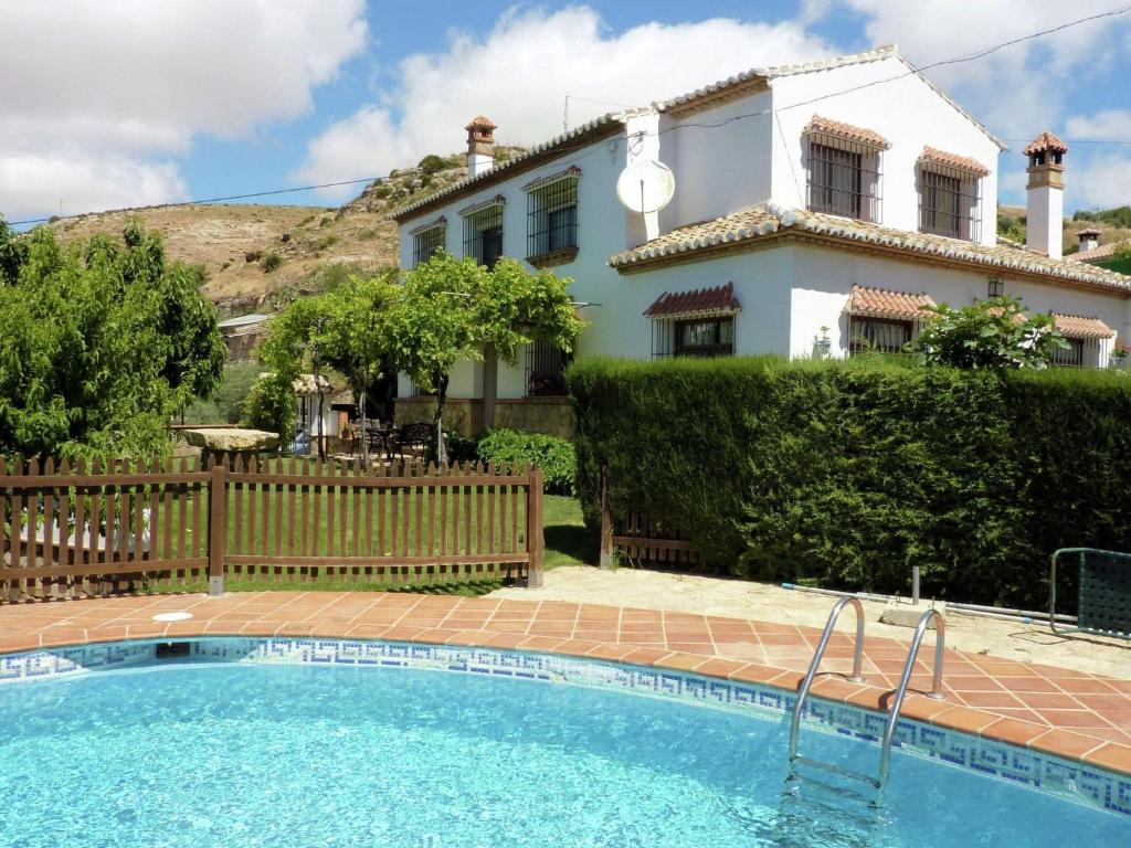 a villa with a swimming pool in front of a house at Belvilla by OYO Casa Almendro in La Joya