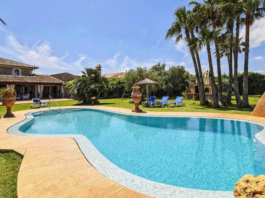 una piscina en un patio con palmeras en Belvilla by OYO Gamundi, en Muro