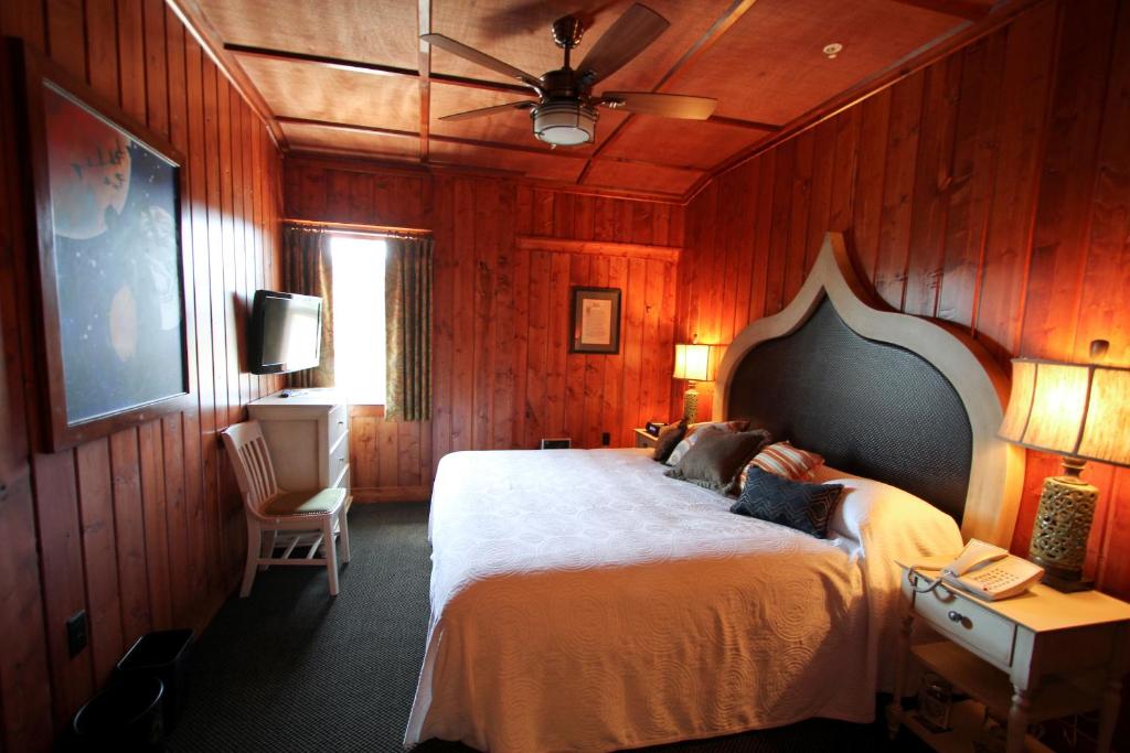 a bedroom with a large bed with wooden walls at McMenamins Gearhart Hotel in Gearhart