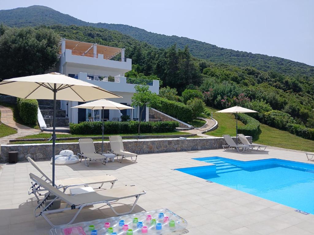 a villa with a swimming pool and a resort at Kapetaniou Apartments in Limniónas