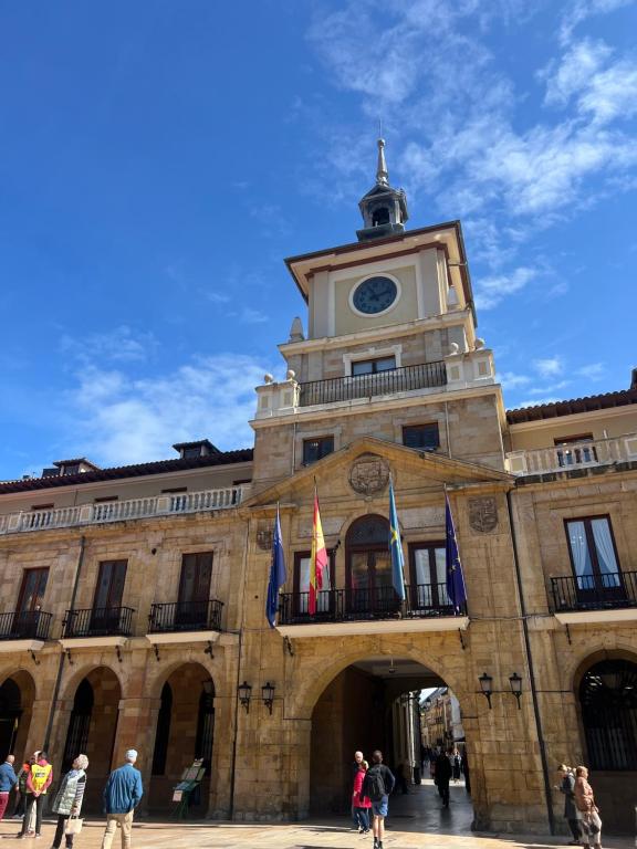 un bâtiment avec une tour d'horloge en haut dans l'établissement La mejor ubicación en Oviedo. Casco histórico., à Oviedo